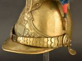 a gold helmet with a blue feather on top of it