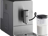 the coffee machine is next to a glass of milk