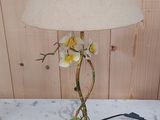 a lamp that has a flower on it on a table