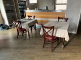 des tables et des chaises dans une pièce avec un bar en arrière-plan