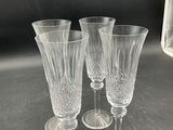 three clear wine glasses sitting on top of a table next to a microwave