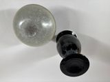 a black and white vase and a glass ball on a white table