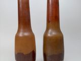 two vases sitting side by side on a white surface
