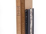 trois livres sont empilés sur une surface blanche