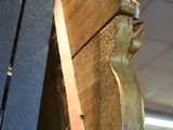 a wooden sculpture of a man holding a book on a shelf