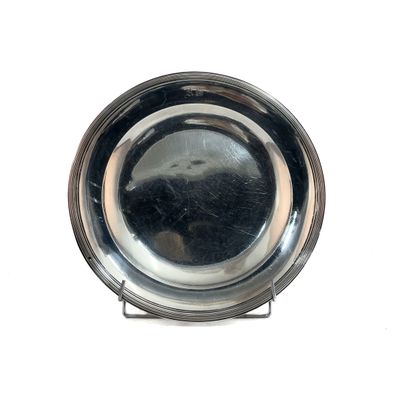 a silver plate on a metal stand on a white surface