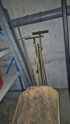 une brouette au milieu d'une pièce où se trouve une échelle