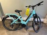 un vélo bleu avec un sac jaune à l'arrière