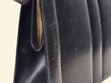 a black purse with a wooden handle on a white background