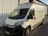La camionnette est garée devant un immeuble sur lequel est accrochée une pancarte.