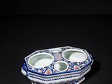 blue and white porcelain bowl with two compartments on a black surface