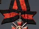 an image of a red and black cross medal with a ribbon around it