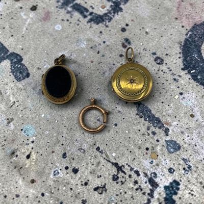 un gros plan sur deux petites boucles dorées posées sur une surface en béton