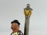 a figurine of a man with a hat and a cane