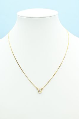 a gold necklace on a mannequin neck with a white background
