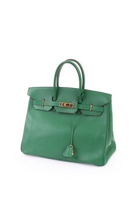a green leather handbag on a white background