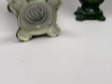 two green vases sitting next to each other on a table