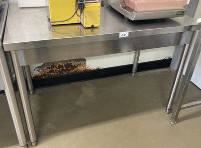 une table en acier inoxydable sur laquelle se trouve un bol de nourriture
