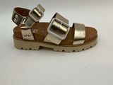 silver sandals with two buckles on each side of them on a white surface