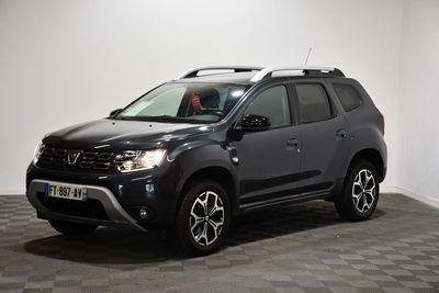 une photo d'une dacia grise garée sur un sol en damier