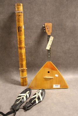 une guitare et une paire de chaussures l'une à côté de l'autre
