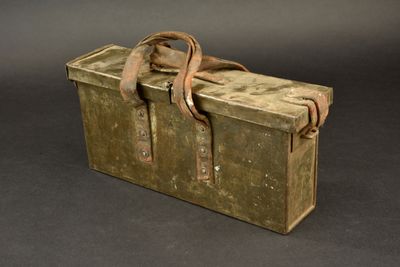 une boîte verte avec une lanière marron