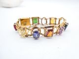 an image of a bracelet with multi colored stones on a white surface