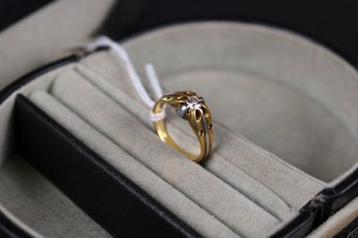 une bague en or dans un étui noir, attachée à un cordon blanc