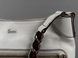 the white purse is sitting on a table with a chain around it