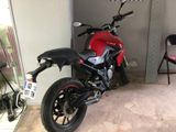 une moto rouge garée dans un garage, à côté d'une chaise