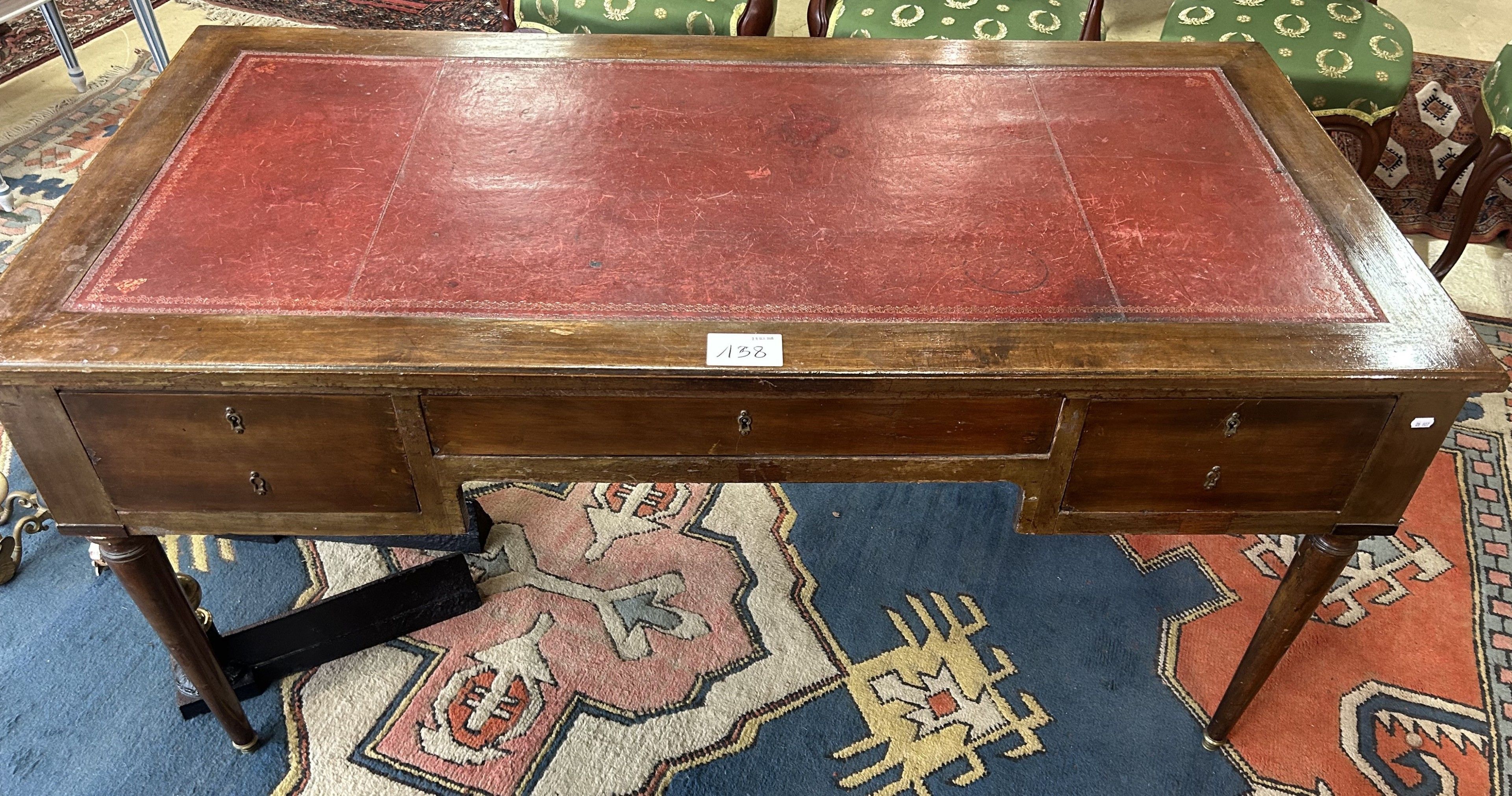 BUREAU plat en acajou gainé de cuir rouge à décor à la roule…