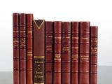 a row of red books sitting on top of a wooden table
