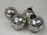 trois boules de Noël en verre argenté posées sur un fond blanc