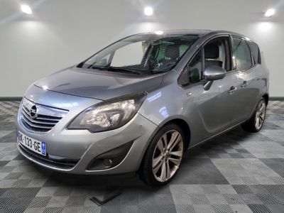 L'Opel argentée est garée dans le garage, sur un sol à damier.