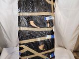 une valise entourée de ruban adhésif, posée sur une chaise blanche