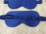 two blue eye masks laying on top of a bamboo mat