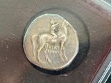 a silver coin with a picture of a man on a horse