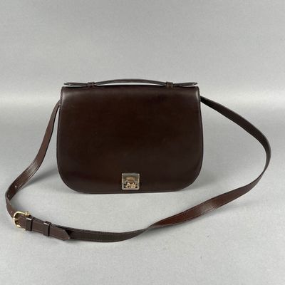 un sac à main en cuir marron muni d'un fermoir métallique et d'une bandoulière marron