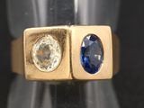 un gros plan d'une bague en or sertie de deux saphirs bleus
