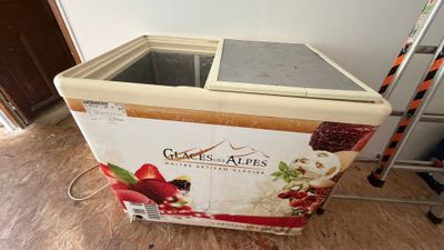 une boîte de glace posée par terre à côté d'une échelle