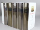 four books are lined up in a row on a gray surface