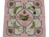 a close up of a pink scarf with a bird and carriage design
