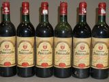 six bouteilles de vin sont alignées sur une table