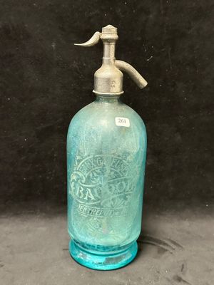 une bouteille en verre bleue munie d'un bec verseur en métal