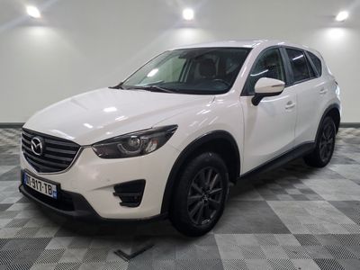La Mazda CX-5 blanche est garée sur un sol à damier.