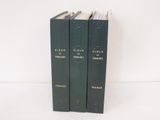 trois livres sont empilés sur une surface blanche