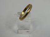 a close up of a gold ring on a clear stand