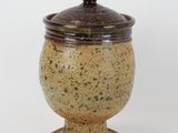 an image of a ceramic jar with a lid on a white background