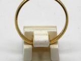 an image of a gold ring on a white marble stand