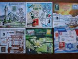 plusieurs timbres différents posés sur une table en bois sur laquelle figure l'image d'un bâtiment
